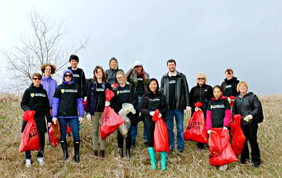 Volunteers holding garbage bags pick up litter on campus.