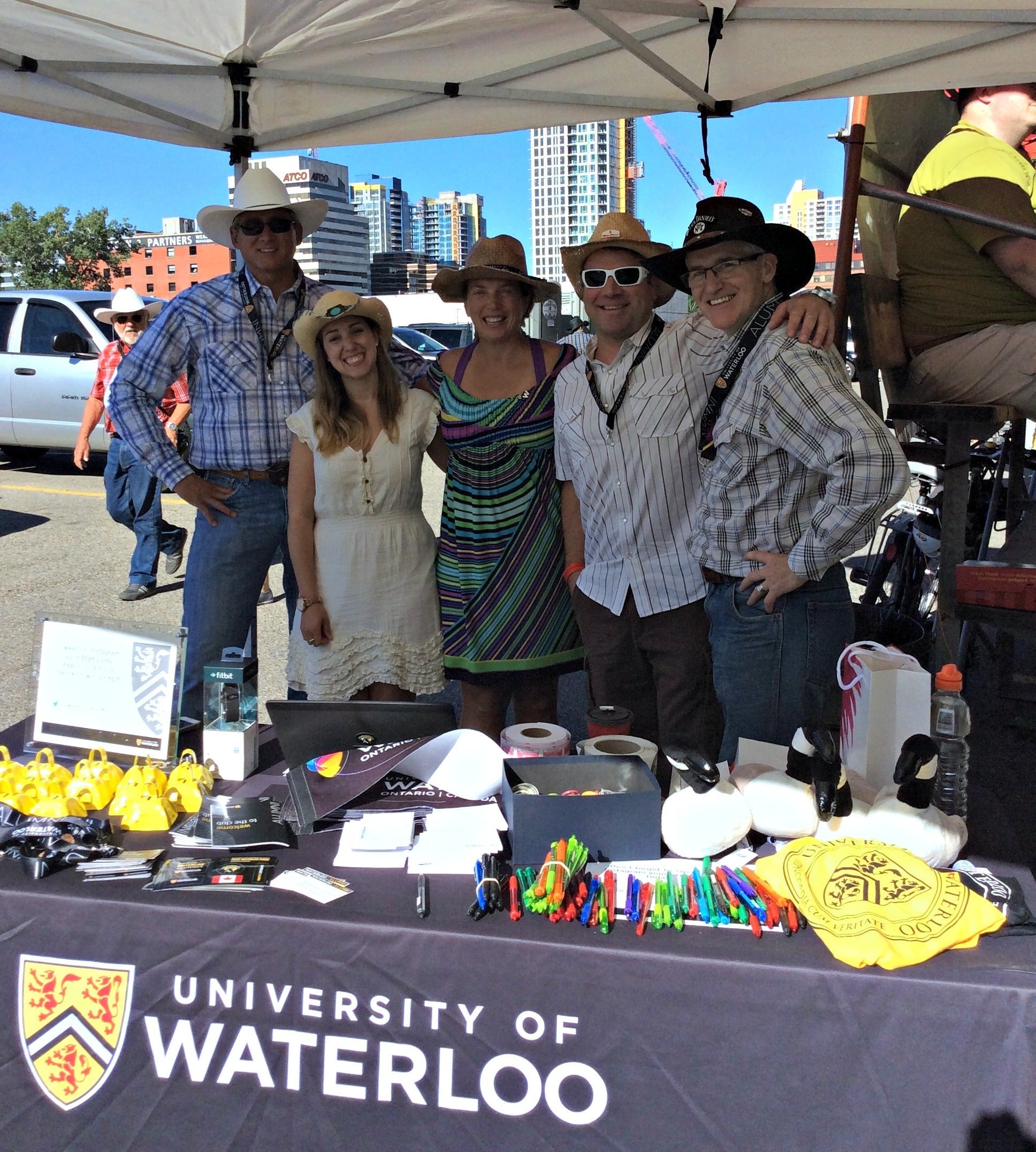 Volunteers in cowboy getups staff a University of Waterloo alumni booth.