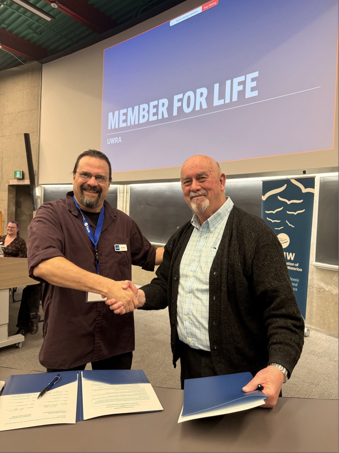 FAUW president David Porreca and UWRA president Ron Champion smile and shake hands.
