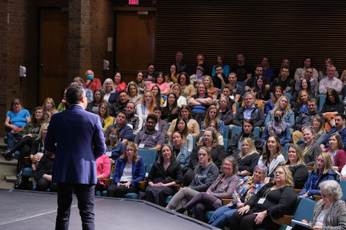 Neil Pasricha speaks to the audience from the Humanities Theatre stage.