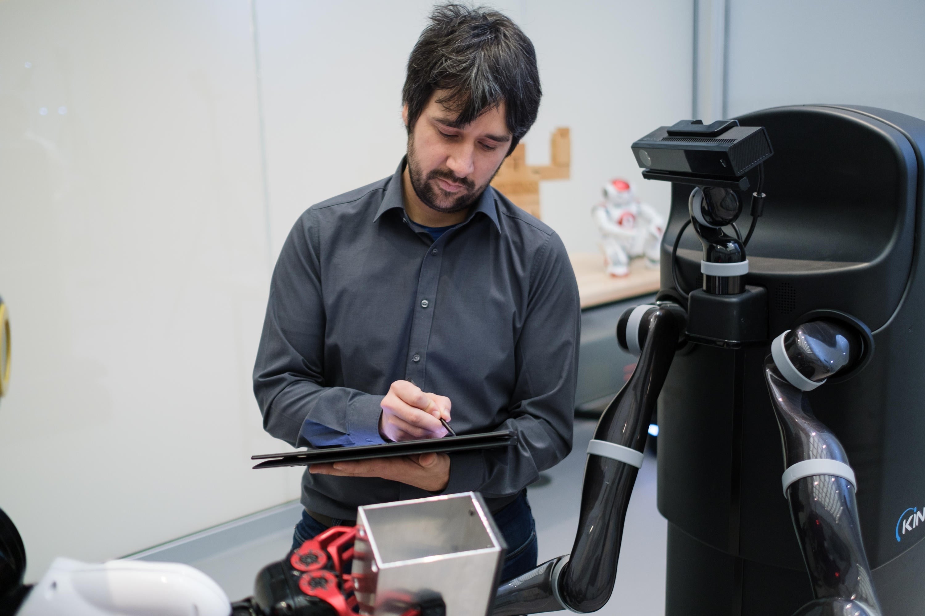 A researcher works with a robot.