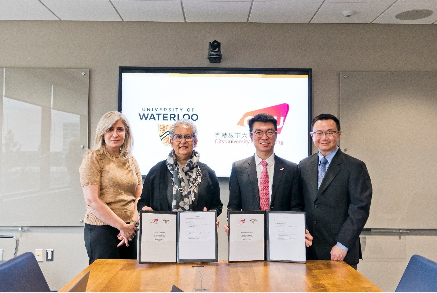 Bessma Momani, Charmaine Dean, Anderson H.C. Shum, and Alfred Yu with the signed MOU documents.
