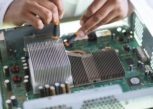 A person repairs the insides of a computer.