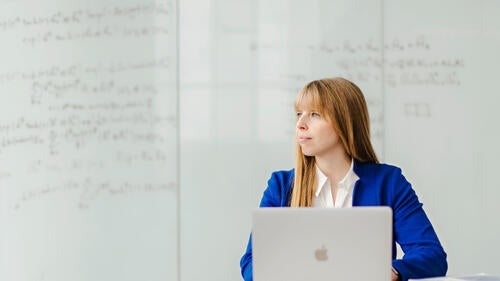 Professor Christine Muschik in front of a whiteboard.