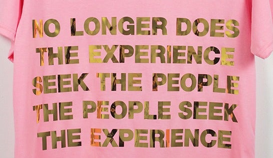 A shirt with the slogan "no longer does the experience seek the people, the people seek the experience."