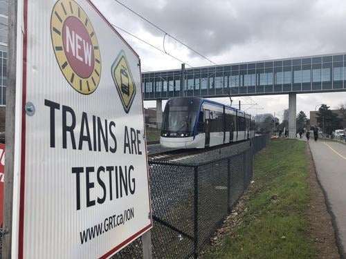 An ION light rail vehicle travels through the University campus on a test run.