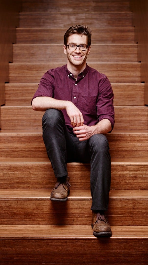 Researcher David Layden sits on a flight of stairs at the Institute for Quantum Computing