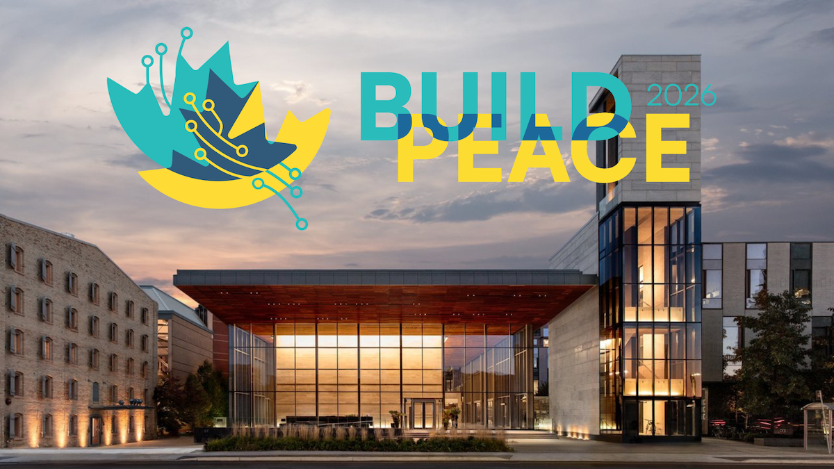The Balsillie School CIGI Campus building at twilight with the Build Peace logo overhead.