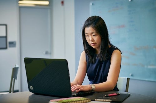 A woman uses a laptop.