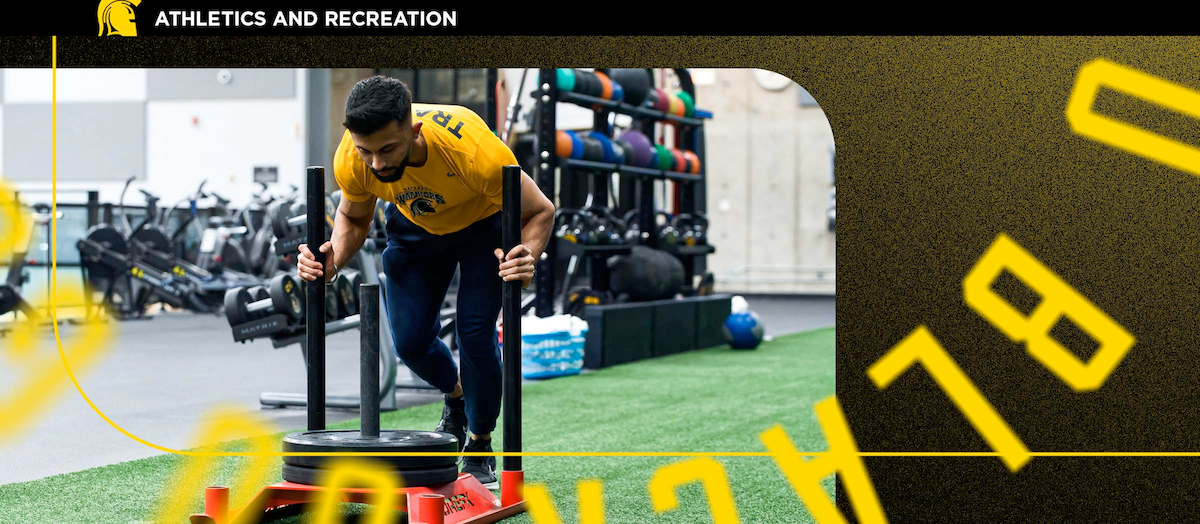 A young man uses exercise equipment in a gym.