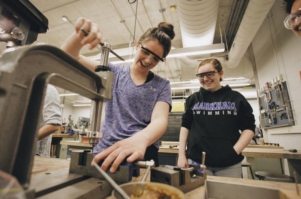 Girls using a drill press at the Catalyst conference.