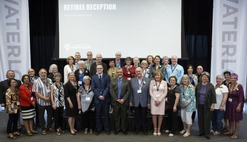 President Feridun Hamdullahpur and retirees stand for a group photo in Fed Hall.