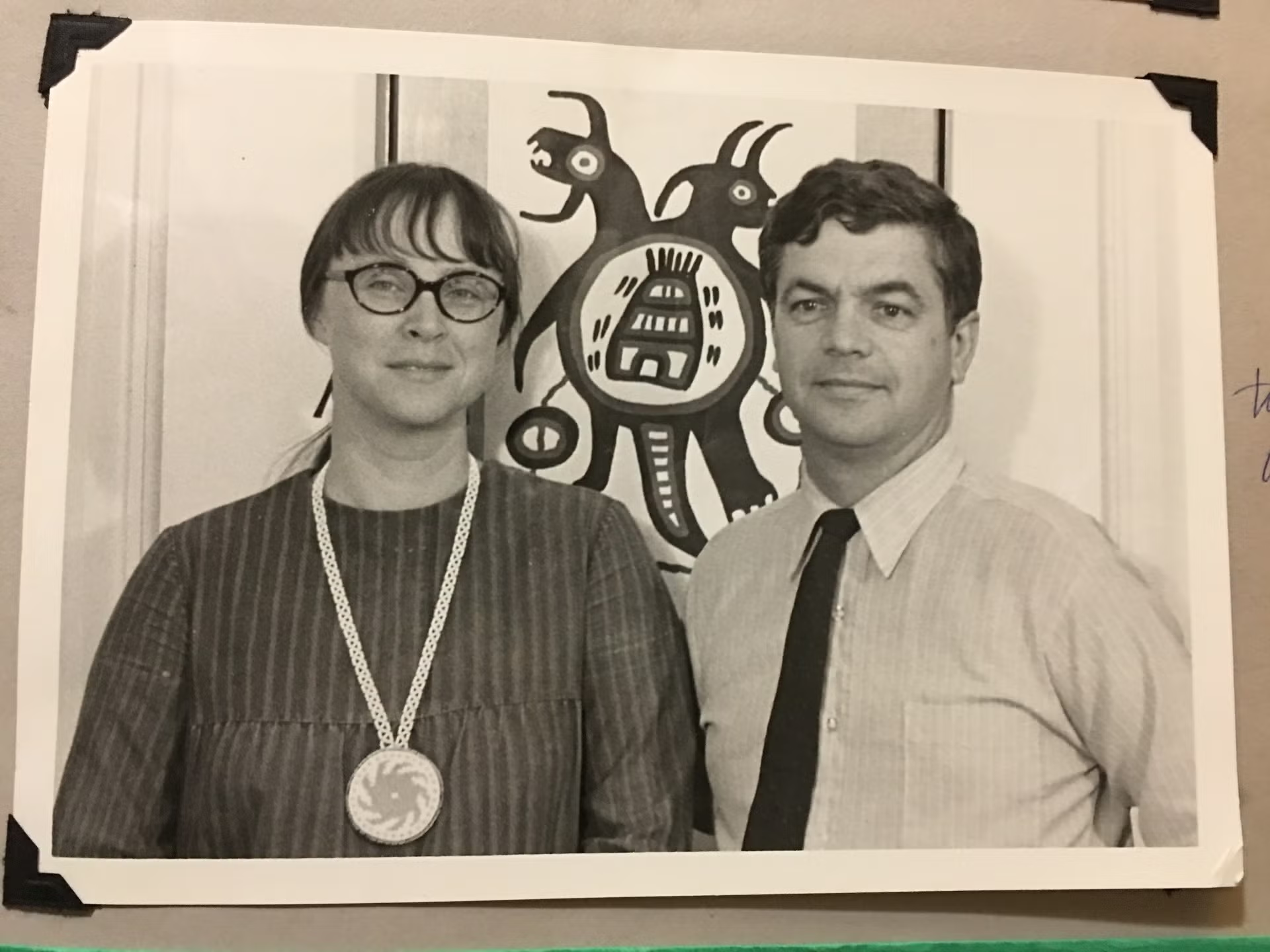 A portrait of Nancy Lou Patterson and E. Palmer Patterson standing in front of Indigenous artwork.