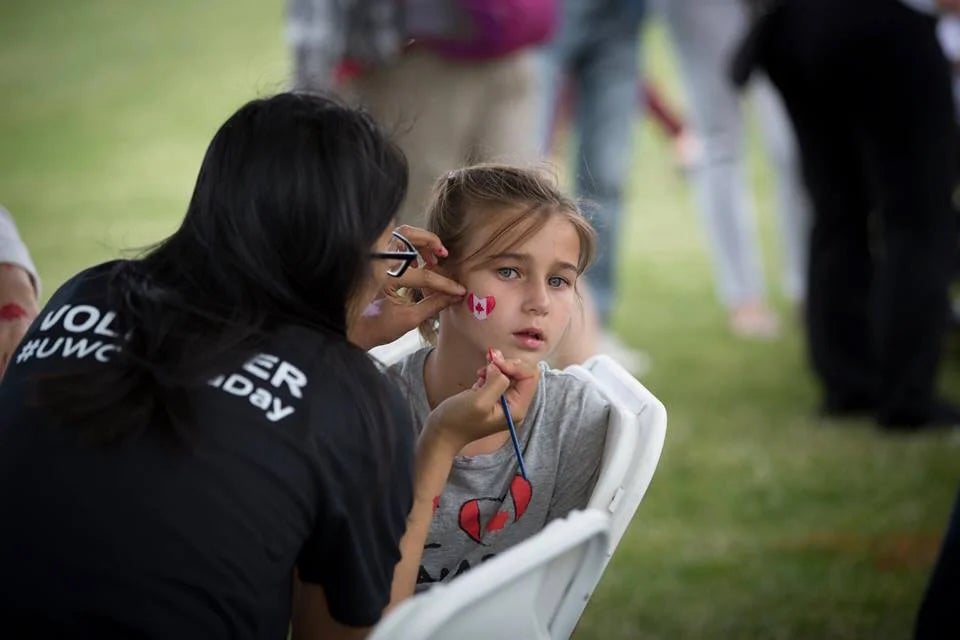 A Waterloo volunteer paints a child's face.