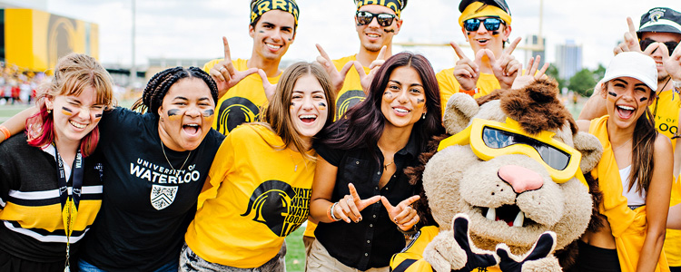 Students in UWaterloo garb pose with King Warrior.