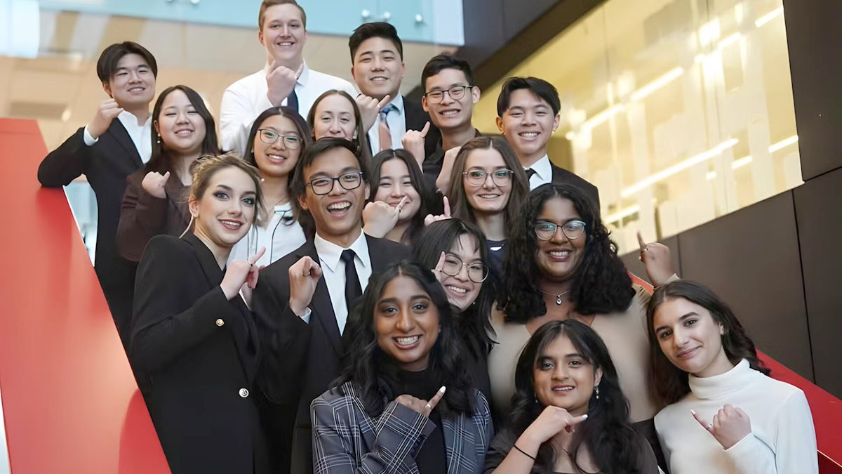 Engineering students hold up their hands to show off their iron rings.