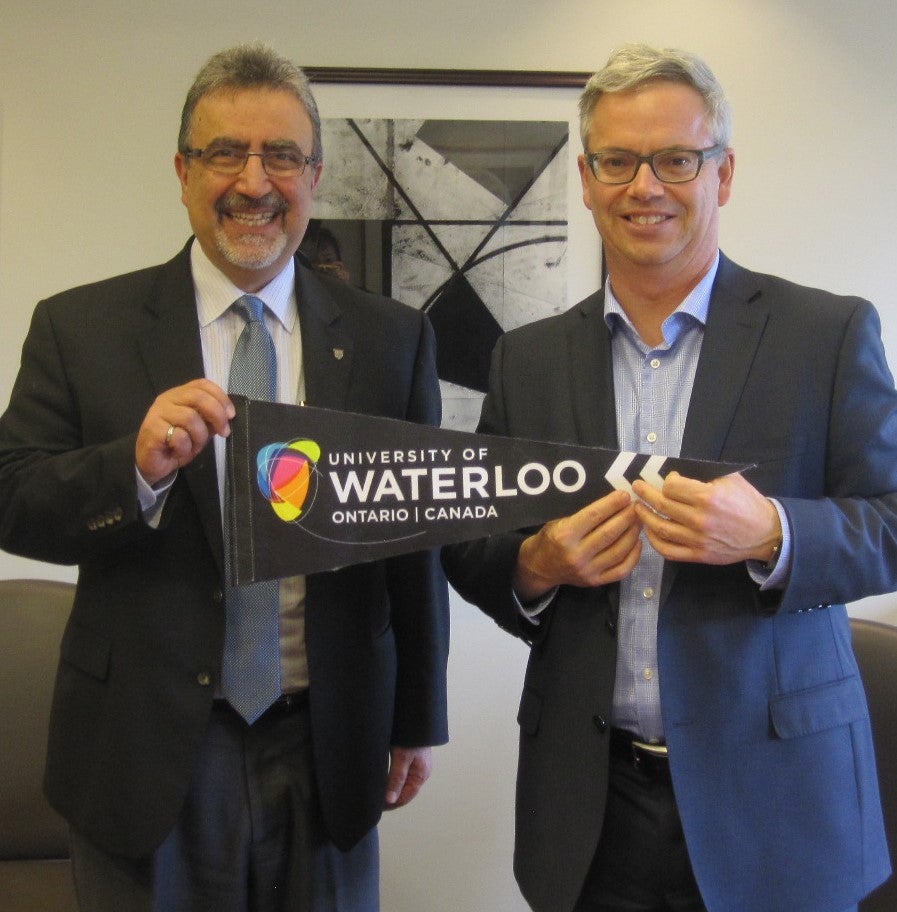 Feridun Hamdullahpur and Sylvain LaPorte pose with the Waterloo pennant.