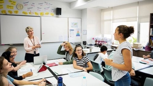 Students and educators interact in a classroom setting.