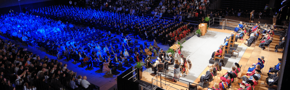 A wide shot of the stage and audience at convocation.