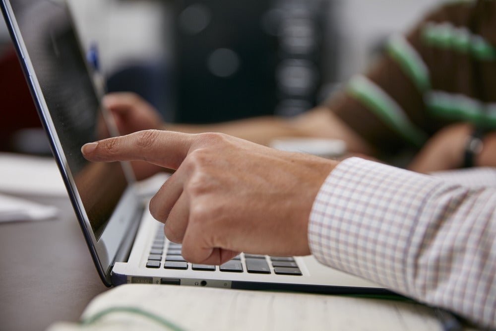 someone pointing at a problem onto a laptop screen