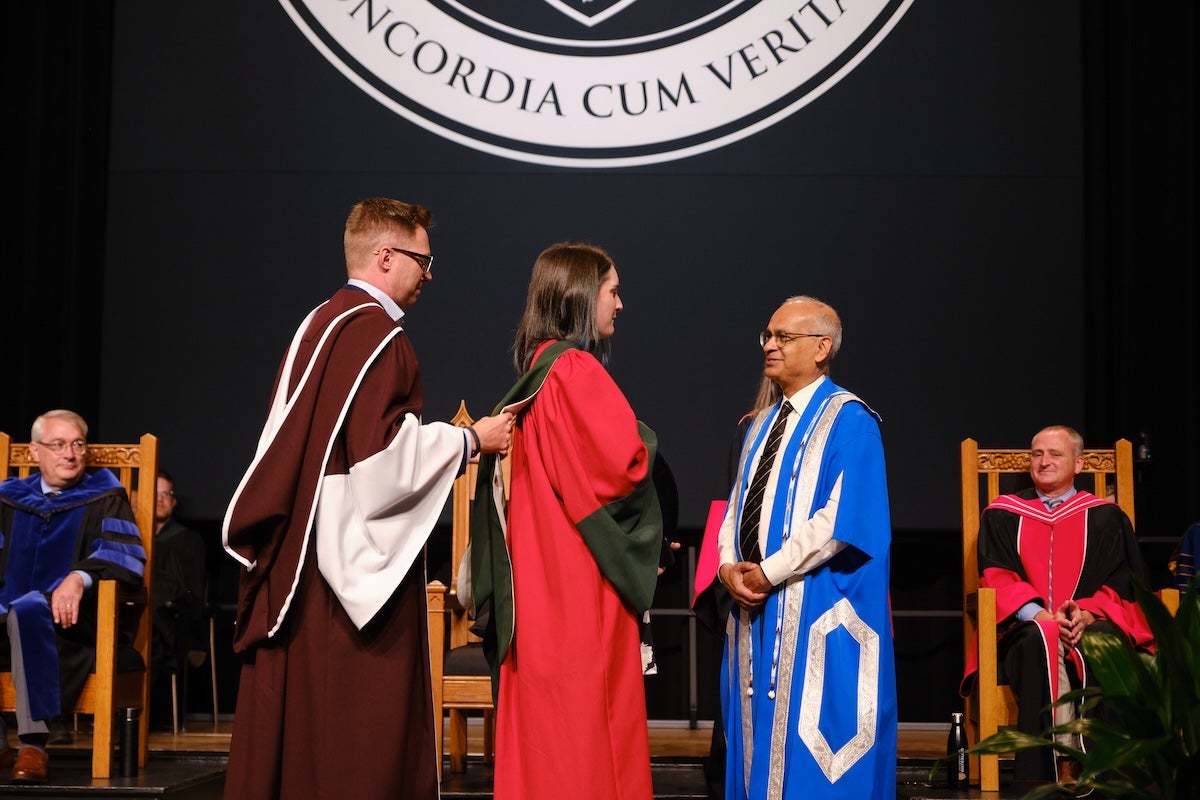 Dr. Vivek Goel speaks with a PhD graduand on stage at the 2024 science convocation ceremony.
