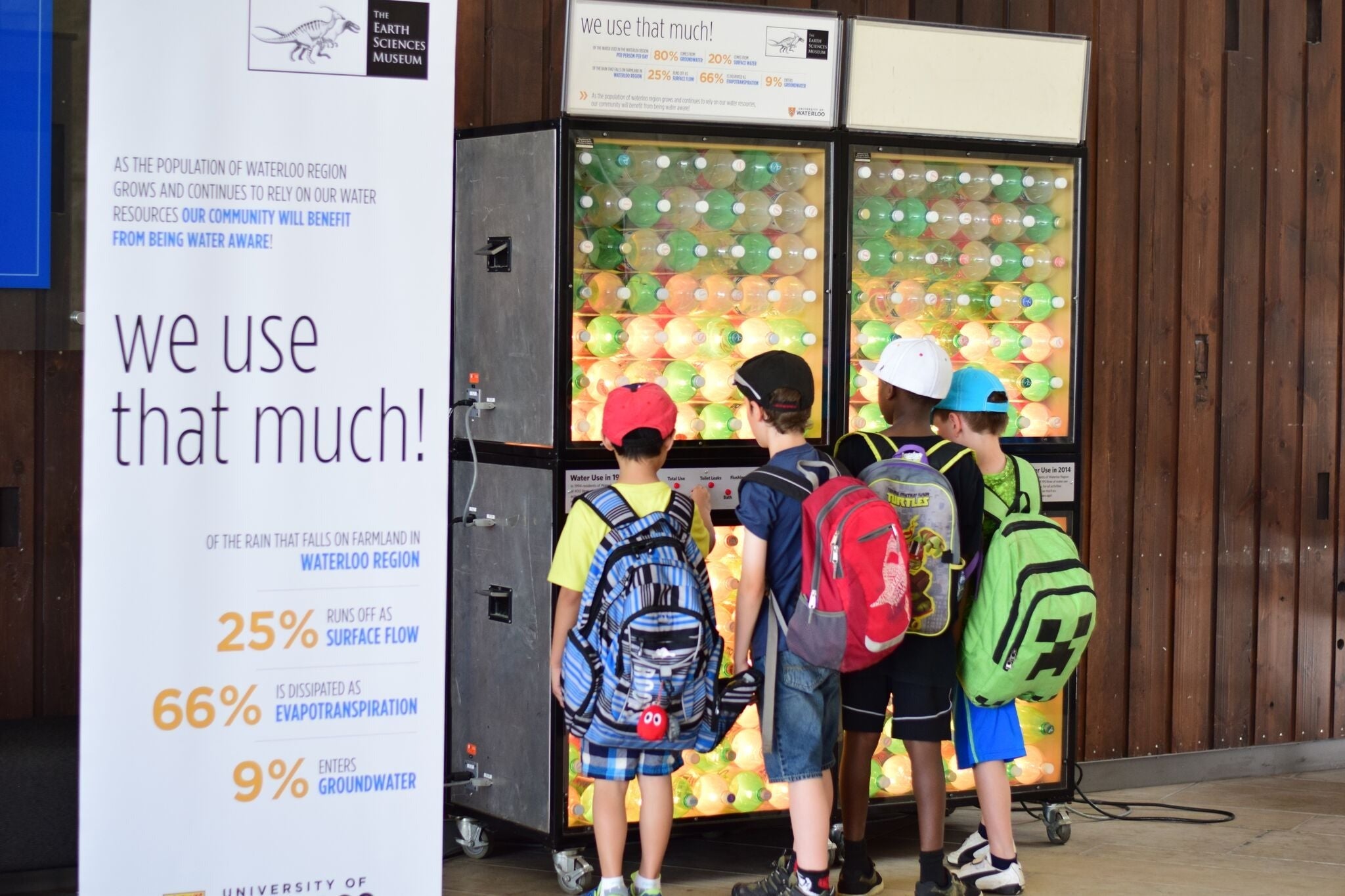 Four kids check out a water usage exhibit.