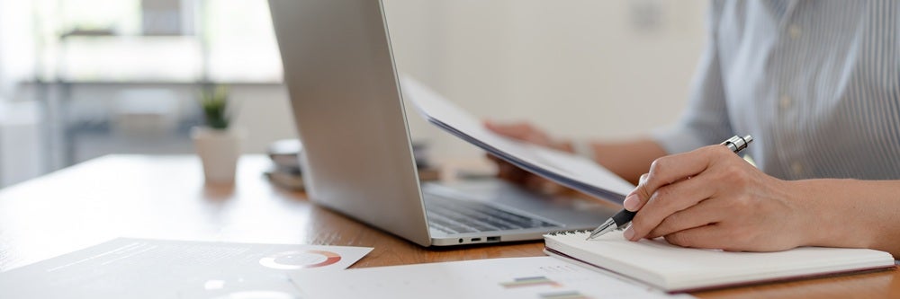 Woman reviewing financial statement and information on her laptop.