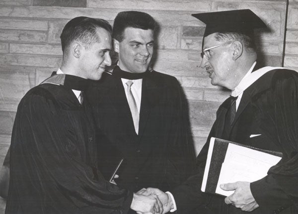 A group of students in robes pose for a group photo.