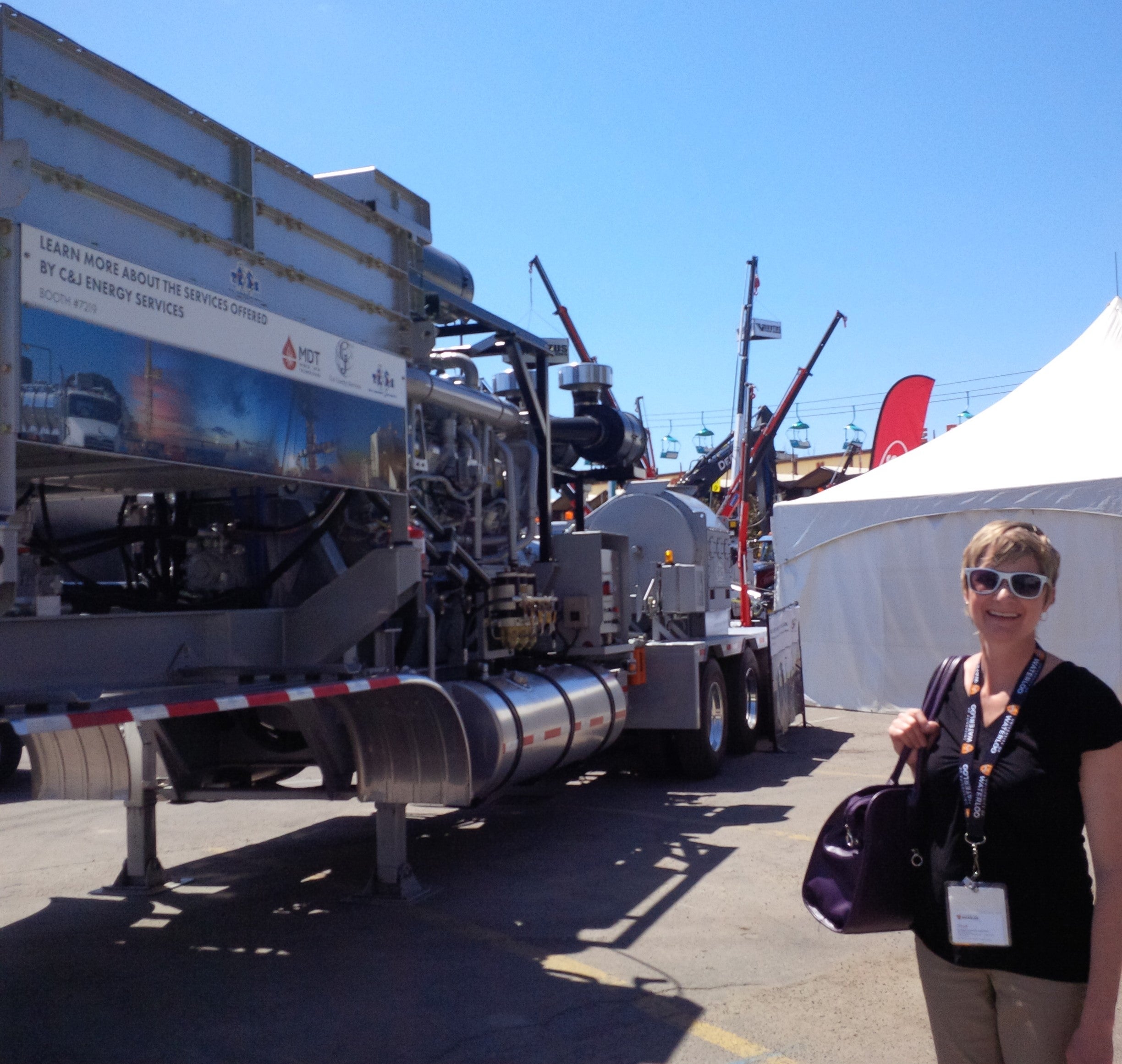 A CECA representative stands next to some petroleum extraction equipment.