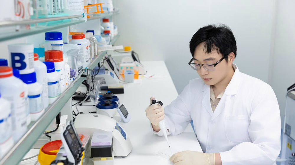 A man in a lab uses tools for testing protein samples.