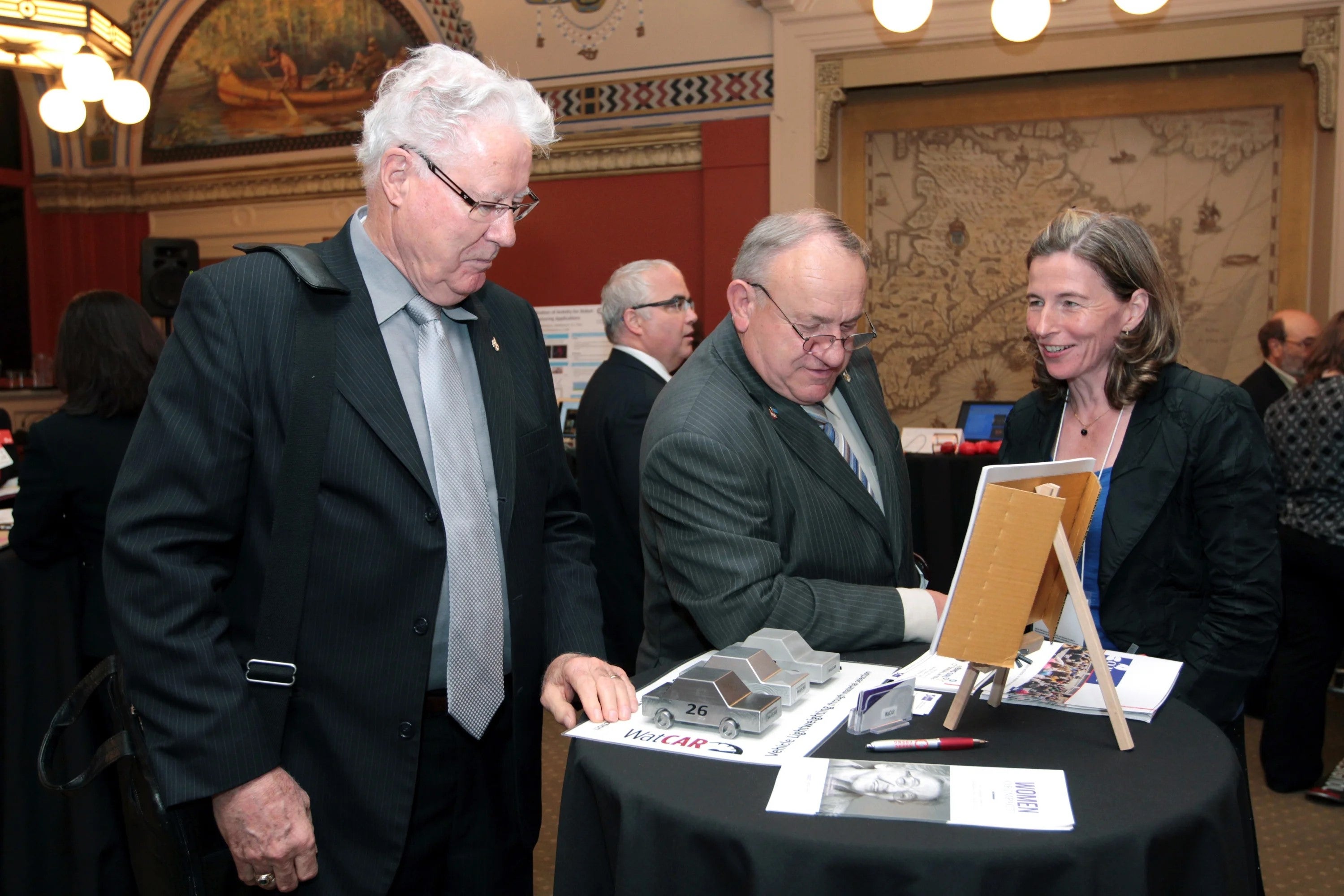 Professor Mary Wells speaks with two members of parliament at her kiosk.
