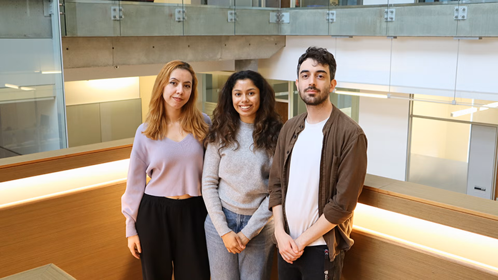 Bruna Shinohara de Mendonça, Ria Chakraborty, and Rodolfo Reis Soldati stand on the stairwell at IQC.