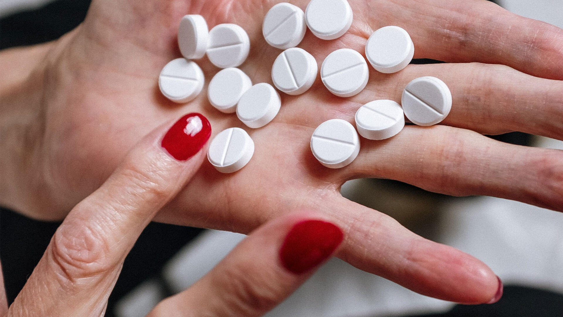 A scattering of pills in a palm of a person's hand.