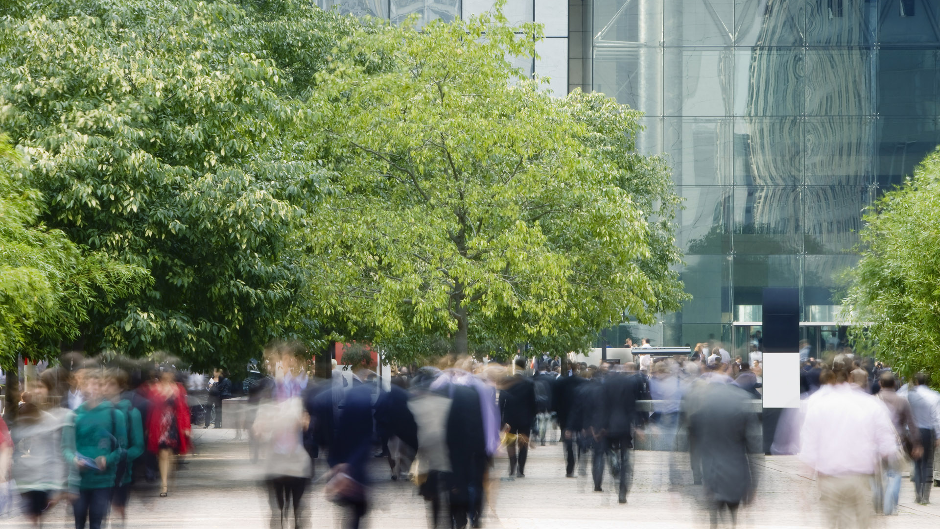 Blurred image of a crowd moving along a street.