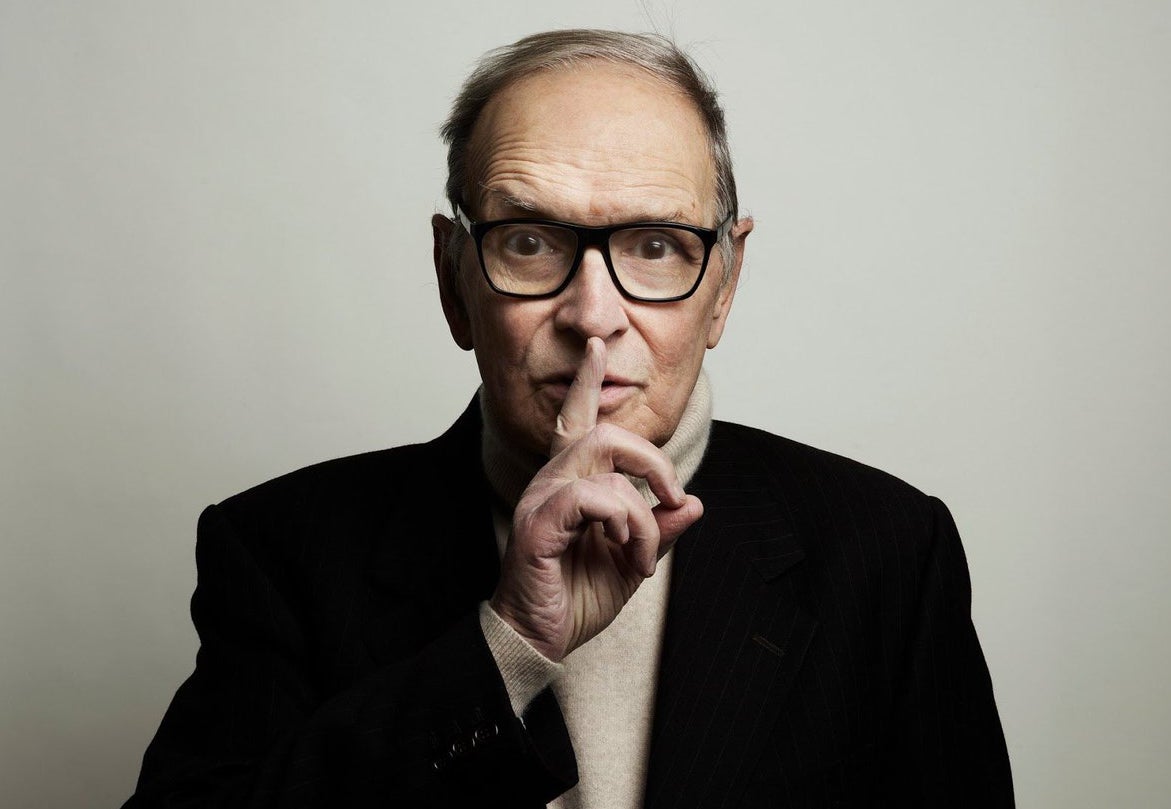 Composer Ennio Morricone raises a finger to his lips.