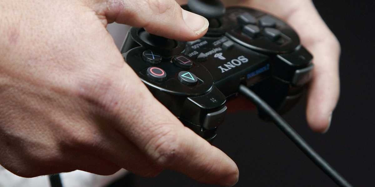 A person holds a PlayStation video game controller.