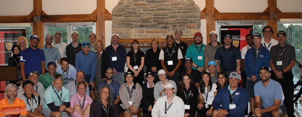 A large group of people in a banquet hall smiling