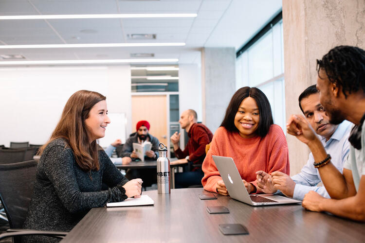 Students chat at a table.