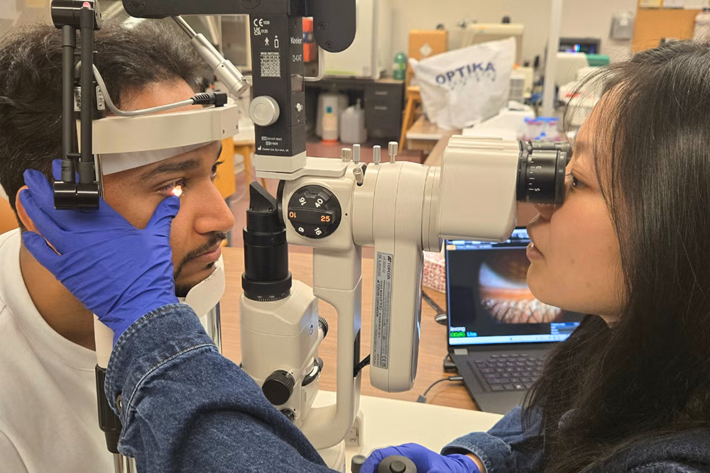 Ivy Vong inspecting the eyes of a patient.