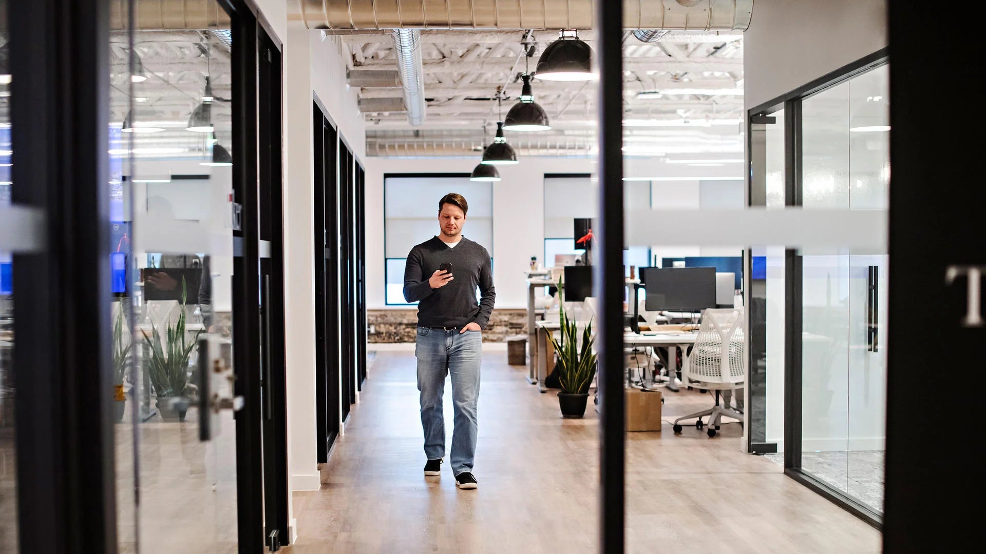Marcelo Cortes checks his phone while walking in his office.