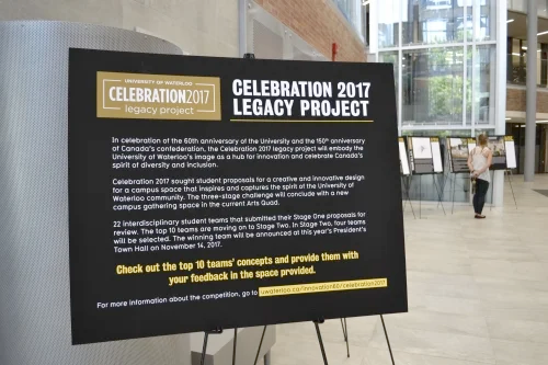 Sign in Hagey Hub for Legacy Project gallery with woman looking at display boards in background