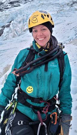 Stephanie Stall wearing a yellow helmet against a snowy background.
