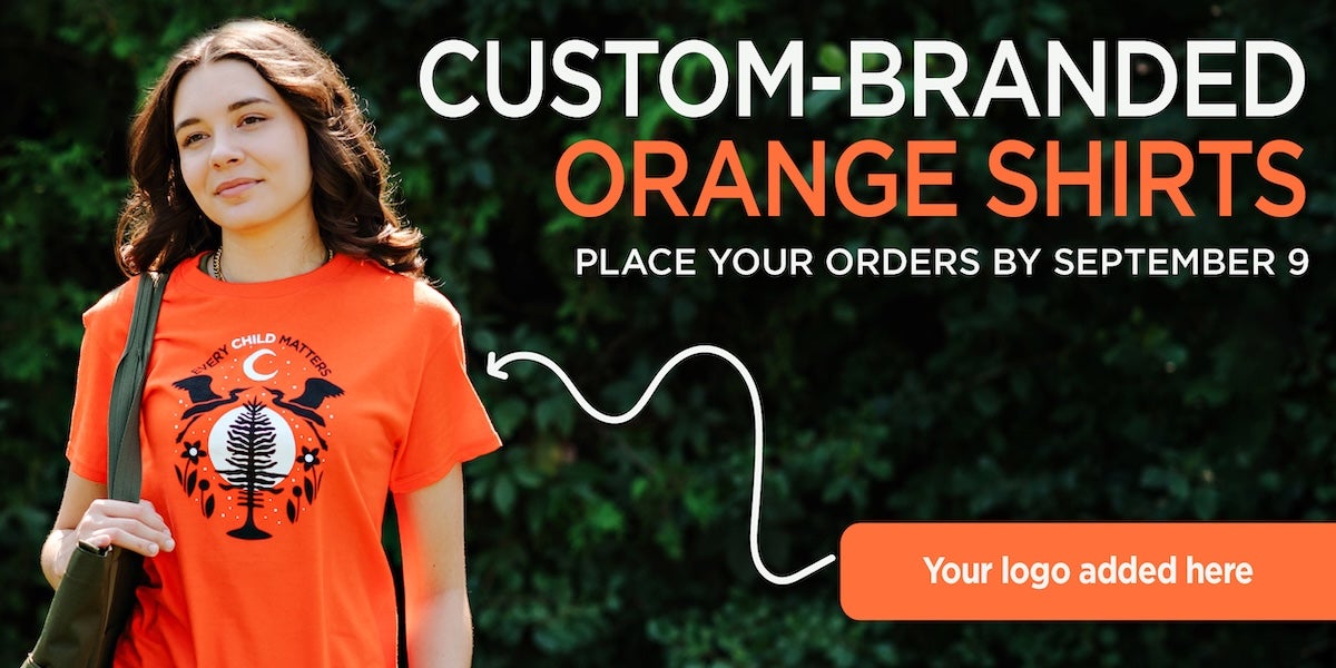 A young woman wearing an “Every Child Matters” Orange Shirt with an Indigenous design featuring two birds, a tree, flowers, and a crescent moon.