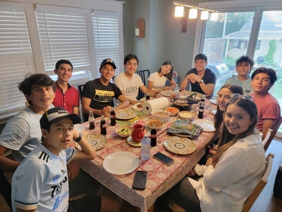 Students sit around a dining room table