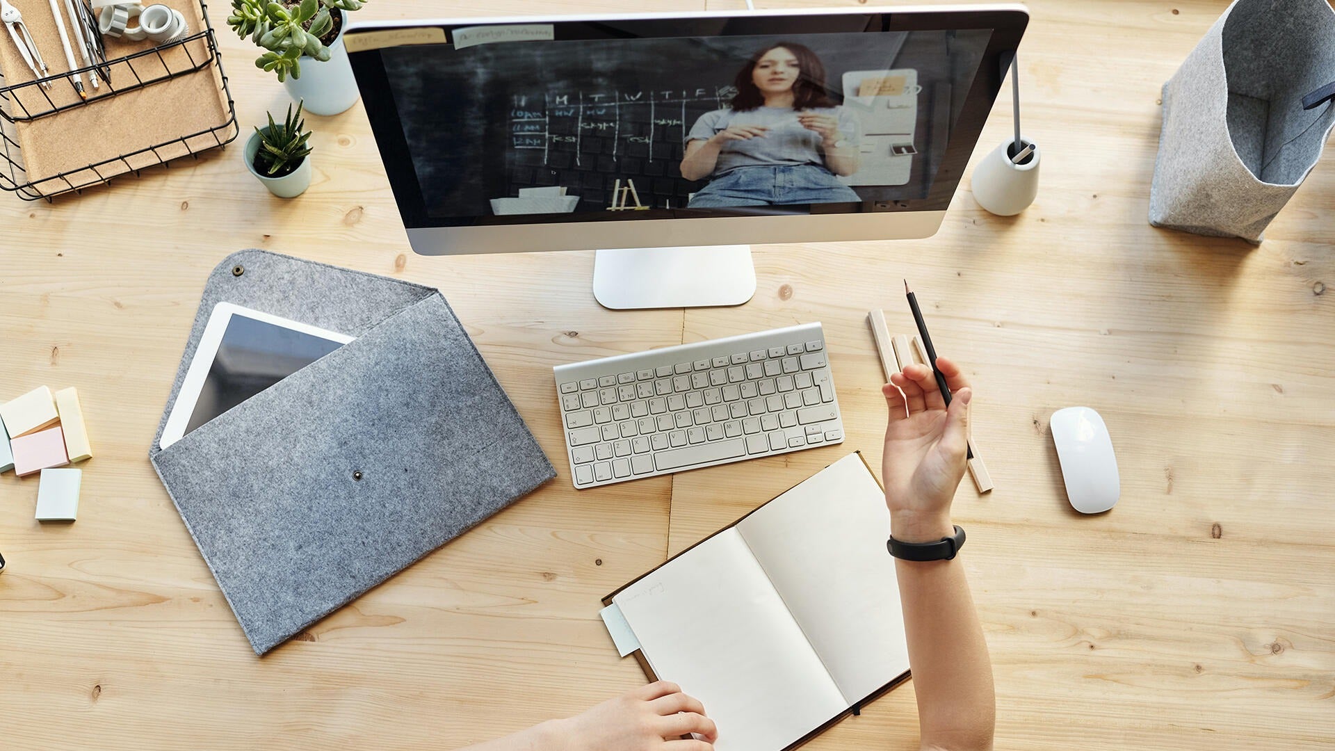 A person takes an online class sitting at their table.