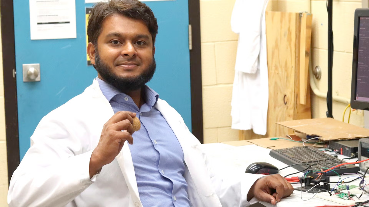PhD candidate Nazmul Hossain holds up a walnut in his lab.