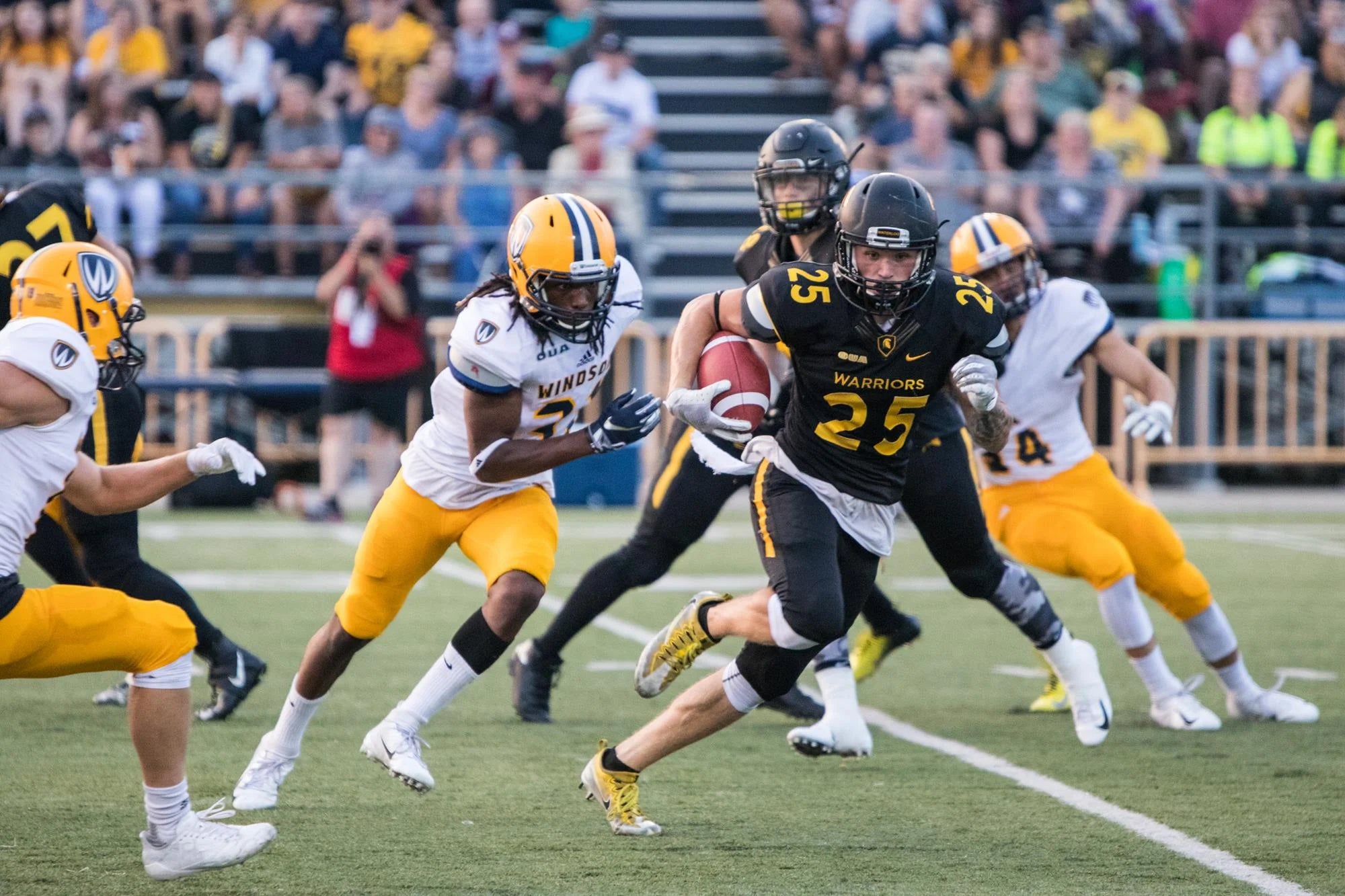 Waterloo and Windsor football players on the field.