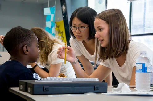 Two students administering an eye test to a child