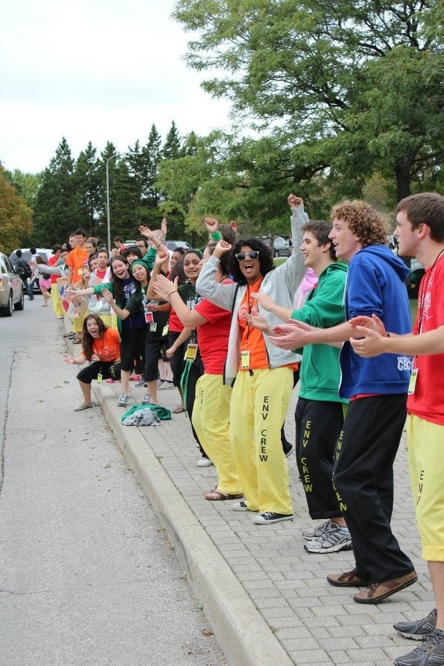 Volunteers line the ring road to welcome new students.