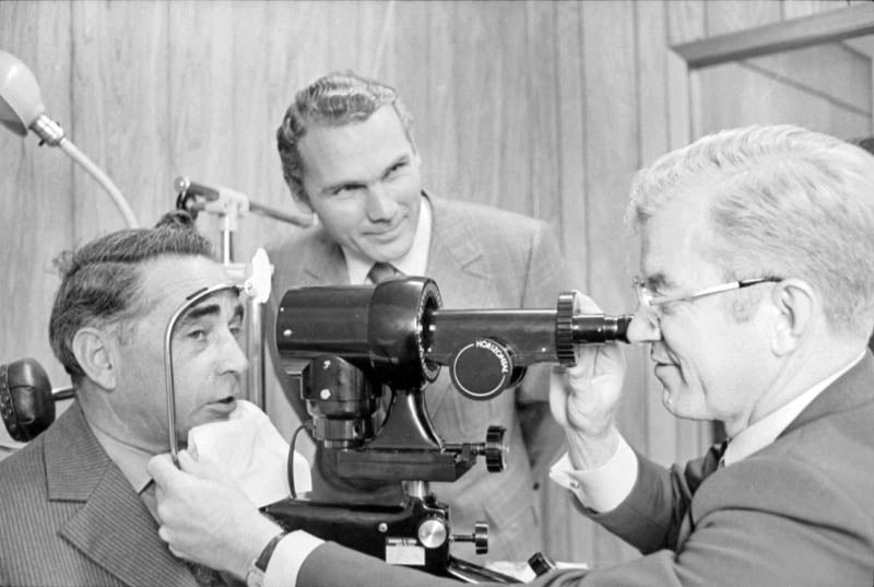 University of Waterloo President Burt Matthews watches an eye exam in process.